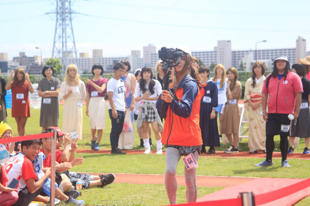 自前の撮影機材を持ってランウェイを歩くみっちゃん